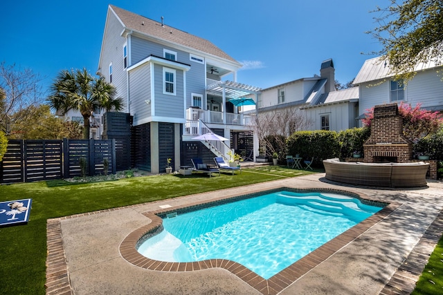 view of swimming pool with stairway, a lawn, a ceiling fan, fence, and a fenced in pool
