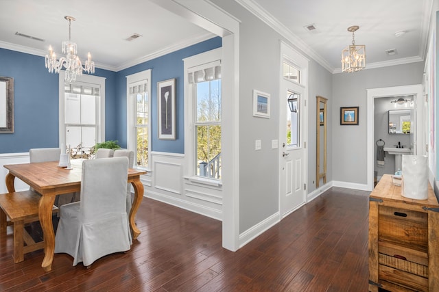 dining space with visible vents, a notable chandelier, and crown molding