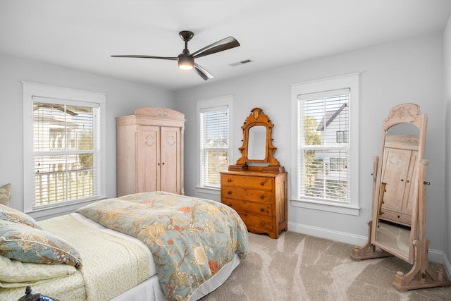 carpeted bedroom with baseboards, a ceiling fan, and visible vents
