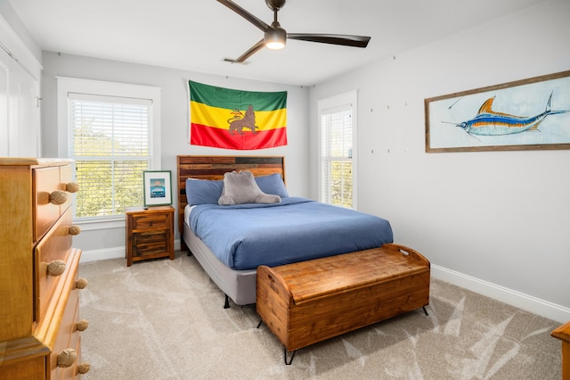 bedroom featuring baseboards, light colored carpet, and multiple windows