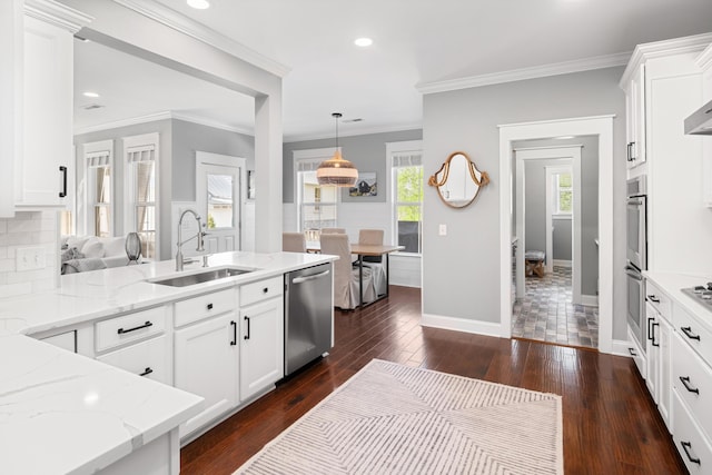 kitchen with a peninsula, a sink, decorative backsplash, light stone countertops, and appliances with stainless steel finishes