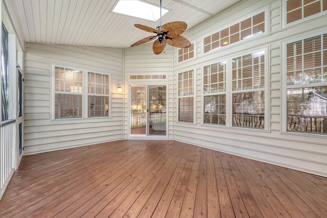unfurnished sunroom featuring a skylight, a ceiling fan, and a healthy amount of sunlight