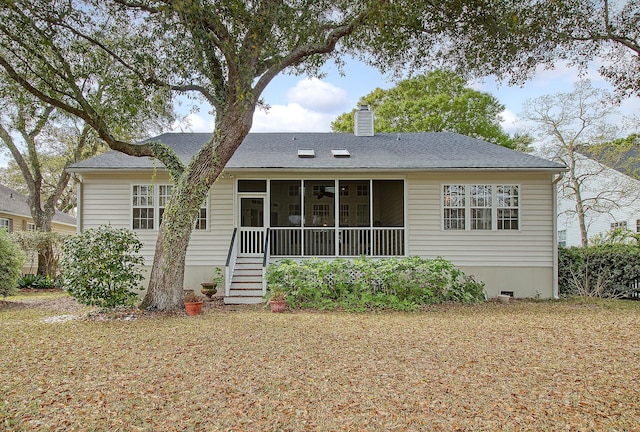 back of house featuring a shingled roof, stairs, a chimney, and a sunroom