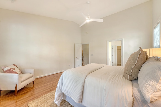bedroom featuring a ceiling fan, high vaulted ceiling, baseboards, and light wood-style floors