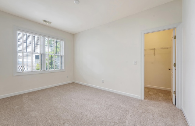 unfurnished bedroom featuring visible vents, baseboards, a closet, a spacious closet, and carpet flooring