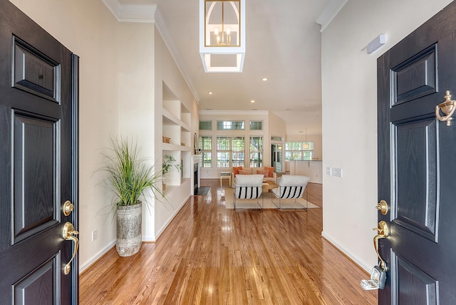 foyer with crown molding, baseboards, recessed lighting, and light wood finished floors