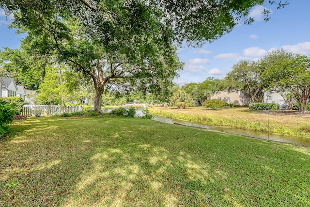 view of yard featuring fence and a water view