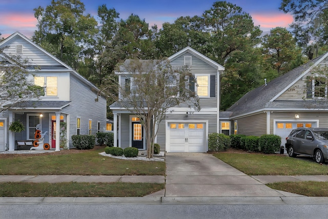 traditional-style house with a yard, an attached garage, and driveway