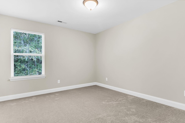 carpeted spare room with visible vents and baseboards