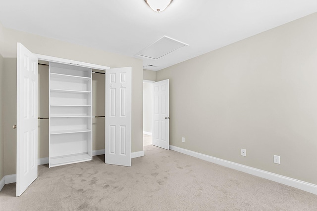 unfurnished bedroom featuring attic access, carpet, baseboards, and a closet