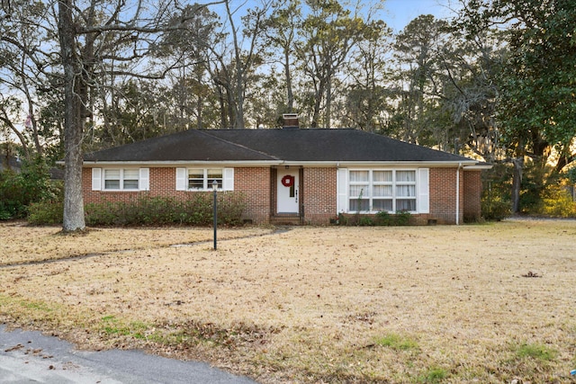 ranch-style home with brick siding and a chimney