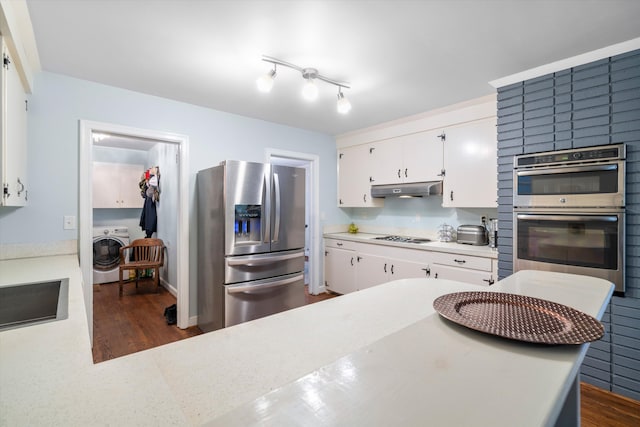 kitchen featuring appliances with stainless steel finishes, washer / clothes dryer, light countertops, and under cabinet range hood