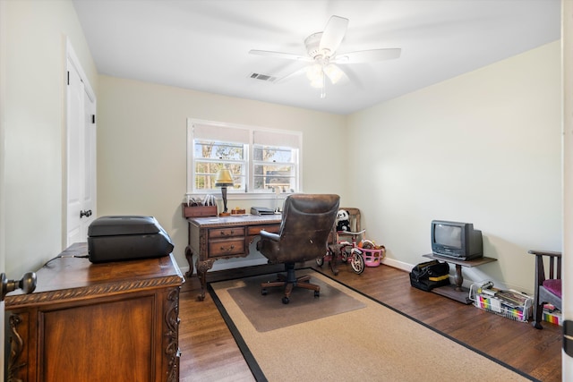 office space with a ceiling fan, baseboards, visible vents, and wood finished floors