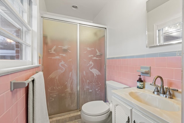 bathroom featuring a wainscoted wall, tile walls, toilet, a stall shower, and vanity