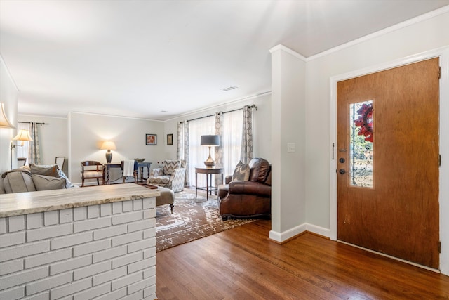 living room featuring ornamental molding, wood finished floors, visible vents, and baseboards