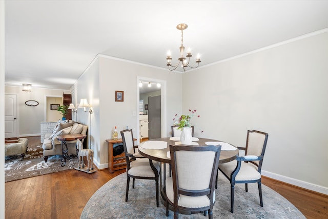 dining room with an inviting chandelier, baseboards, wood finished floors, and ornamental molding