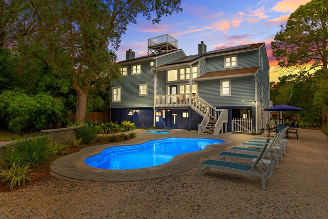 pool at dusk featuring a patio