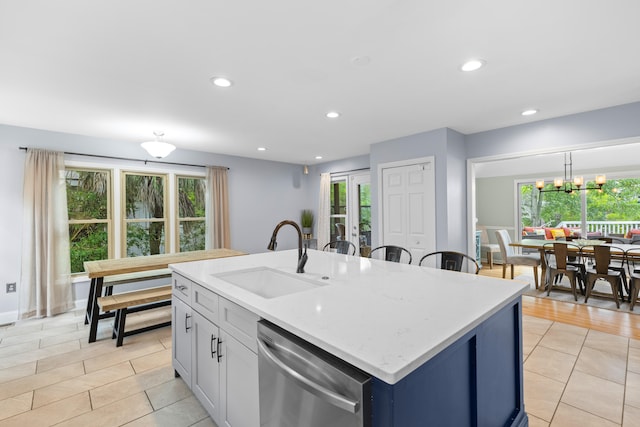 kitchen featuring dishwasher, a wealth of natural light, a kitchen island with sink, and sink