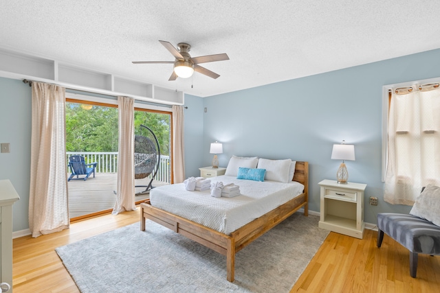 bedroom with ceiling fan, a textured ceiling, access to outside, and light hardwood / wood-style flooring