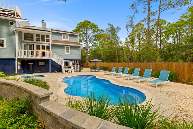 view of swimming pool with a wooden deck and a patio