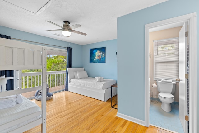 bedroom with a textured ceiling, access to outside, ensuite bath, ceiling fan, and light wood-type flooring