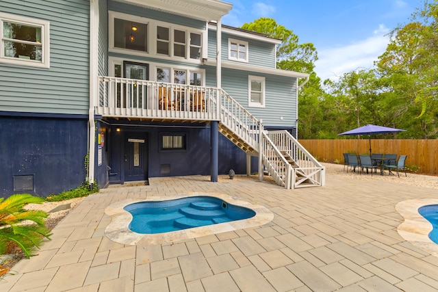 back of house with a patio and a hot tub