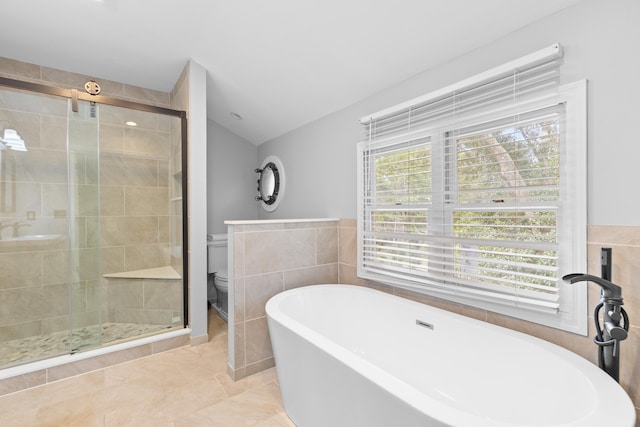 bathroom with separate shower and tub, toilet, vaulted ceiling, and a healthy amount of sunlight