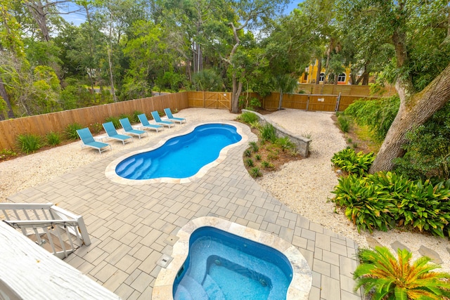 view of swimming pool featuring a jacuzzi and a patio