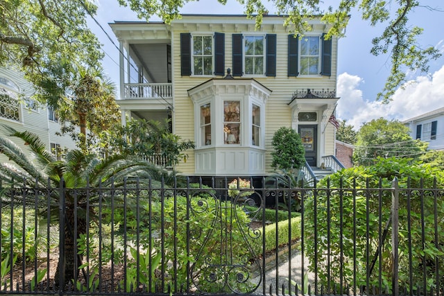 5 Logan St, Charleston, SC 29401 - italianate house featuring a balcony and a fenced front yard