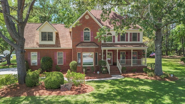 8661 Laurel Grove Ln, North Charleston, SC 29420 - view of front of property with covered porch, brick siding, roof with shingles, and a front lawn