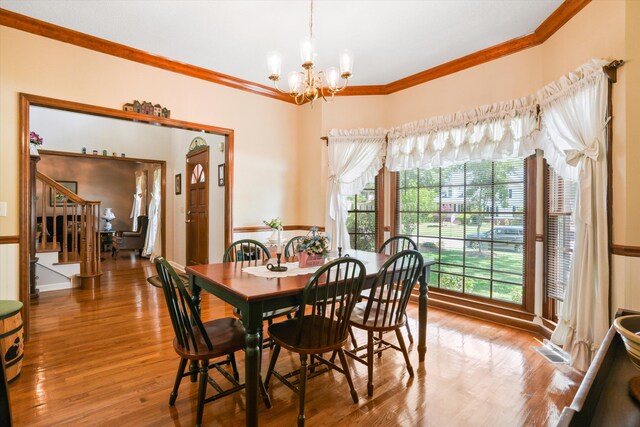 8661 Laurel Grove Ln, North Charleston, SC 29420 - dining room with an inviting chandelier, wood finished floors, visible vents, ornamental molding, and stairway