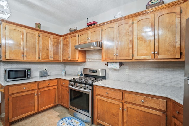 8661 Laurel Grove Ln, North Charleston, SC 29420 - kitchen with a textured ceiling, tasteful backsplash, brown cabinets, under cabinet range hood, and stainless steel appliances