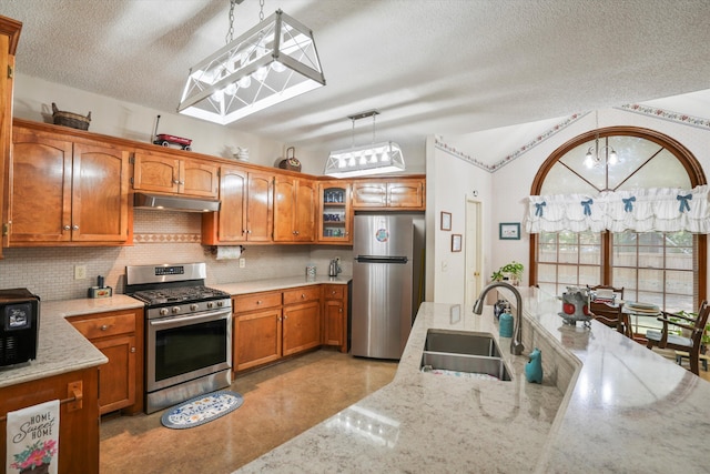 8661 Laurel Grove Ln, North Charleston, SC 29420 - kitchen with appliances with stainless steel finishes, a sink, a textured ceiling, brown cabinetry, and under cabinet range hood