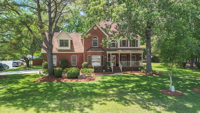 8661 Laurel Grove Ln, North Charleston, SC 29420 - traditional-style home with brick siding, a shingled roof, a front lawn, and covered porch