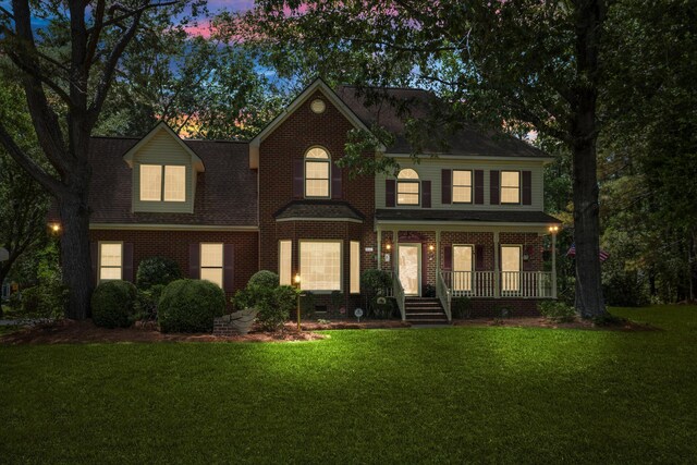 8661 Laurel Grove Ln, North Charleston, SC 29420 - view of front of house with covered porch, brick siding, roof with shingles, and a front lawn
