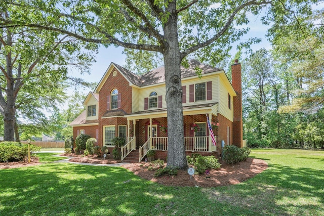 8661 Laurel Grove Ln, North Charleston, SC 29420 - traditional-style house featuring covered porch, brick siding, a chimney, and a front lawn