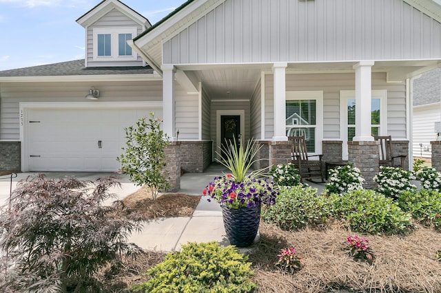 view of front of home featuring covered porch, driveway, an attached garage, a shingled roof, and brick siding