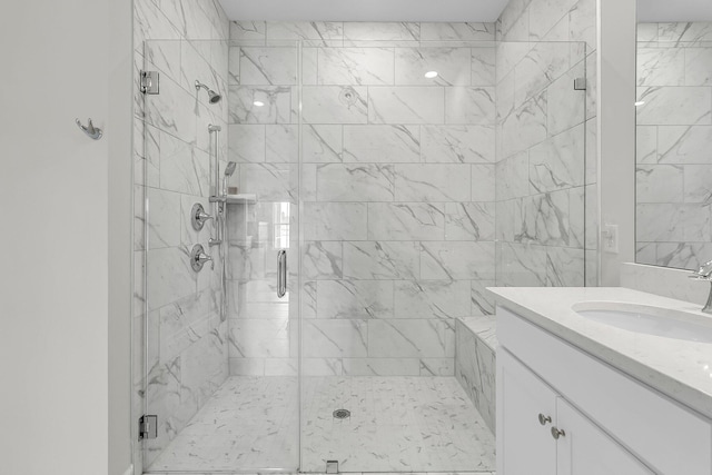 bathroom featuring a marble finish shower and vanity