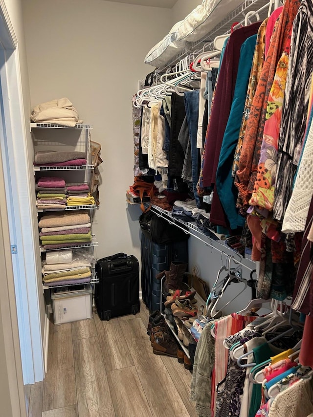 walk in closet with wood finished floors