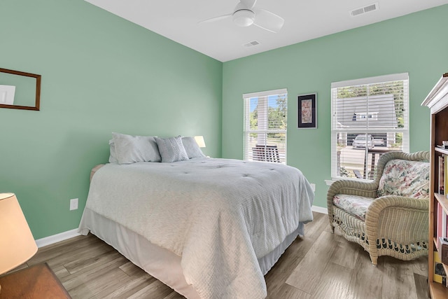 bedroom with wood finished floors, baseboards, and a ceiling fan