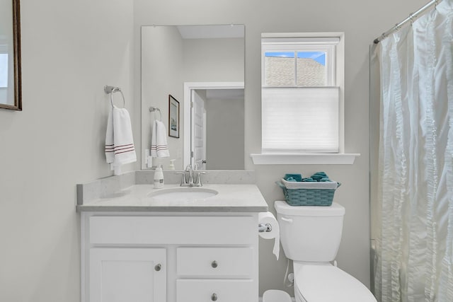 bathroom with toilet, vanity, and curtained shower