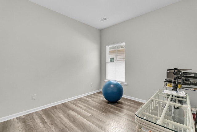 exercise room featuring wood finished floors and baseboards