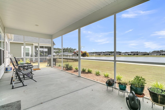 sunroom / solarium featuring a residential view and a water view