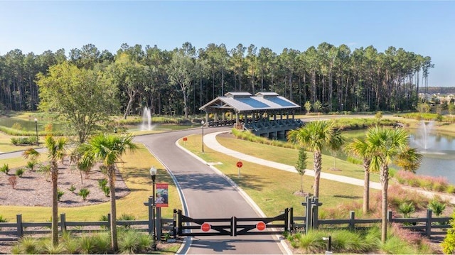 view of community featuring a water view and fence