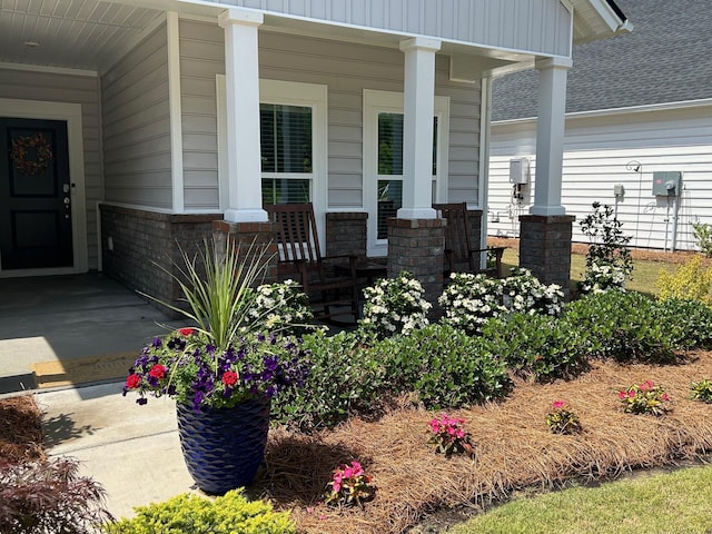 view of exterior entry with covered porch and stone siding