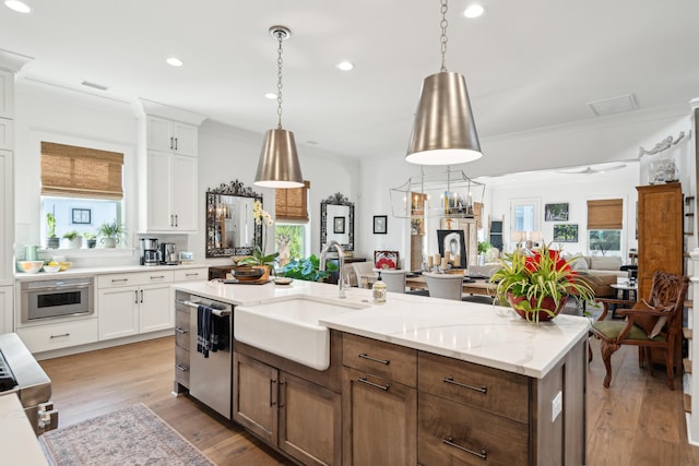 kitchen with appliances with stainless steel finishes, white cabinetry, and plenty of natural light