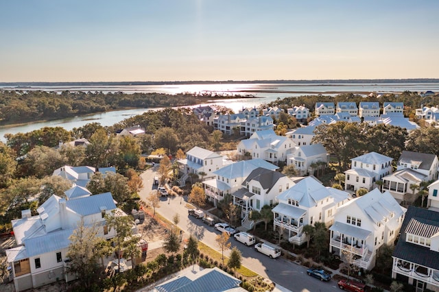 aerial view at dusk featuring a water view