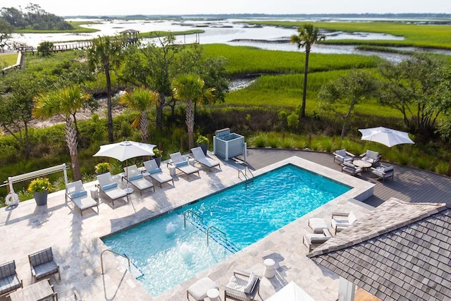 view of swimming pool featuring a water view and a patio area