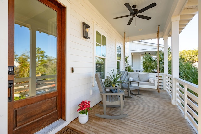 wooden deck featuring covered porch and ceiling fan