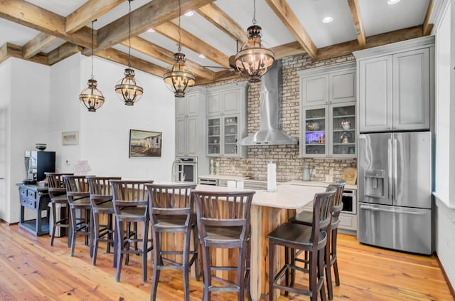 307 Morning Marsh Ln, Charleston, SC 29492 - kitchen with appliances with stainless steel finishes, wall chimney exhaust hood, light wood-style flooring, light countertops, and glass insert cabinets